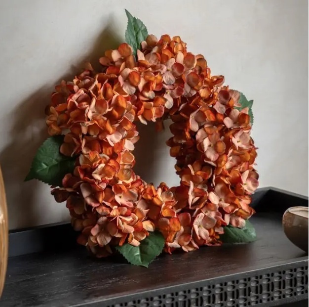 Rust hydrangea wreath with autumnal flowers and green leaves